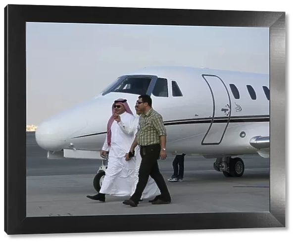 Businessmen walking past Cessna at Dubai Airshow 2005