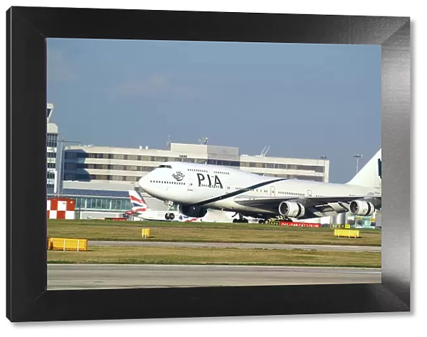 pia;747;landing;airport terminal inbackground;bright sunny day;manchester
