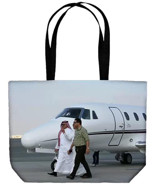 Businessmen walking past Cessna at Dubai Airshow 2005
