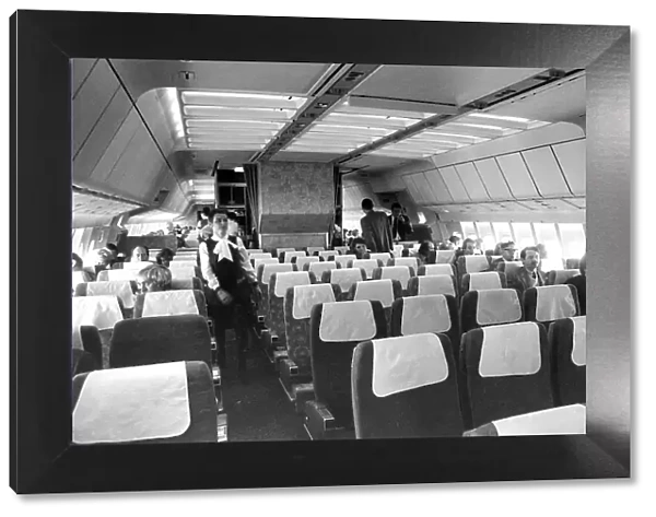 Airliner cabin in 1970s with passenger (rear middle) smoking on board