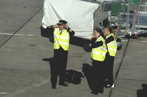 Aer Arran flight crew protecting hearing whilst standing on tarmac at Cork Airport, Ireland