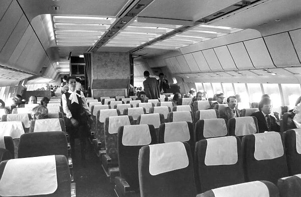 Airliner cabin in 1970s with passenger (rear middle) smoking on board