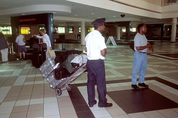 Airport Porter USA. porter pulling trolley with cases birmingham alabama usa hobbs