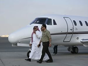 Images Dated 24th November 2005: Businessmen walking past Cessna at Dubai Airshow 2005